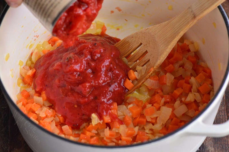 adding tomatoes to the pot