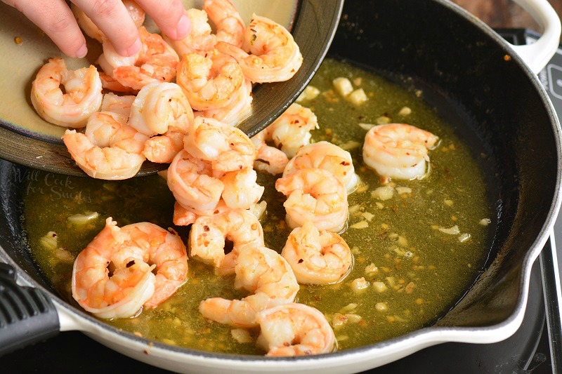 adding shrimp back to the pan with sauce