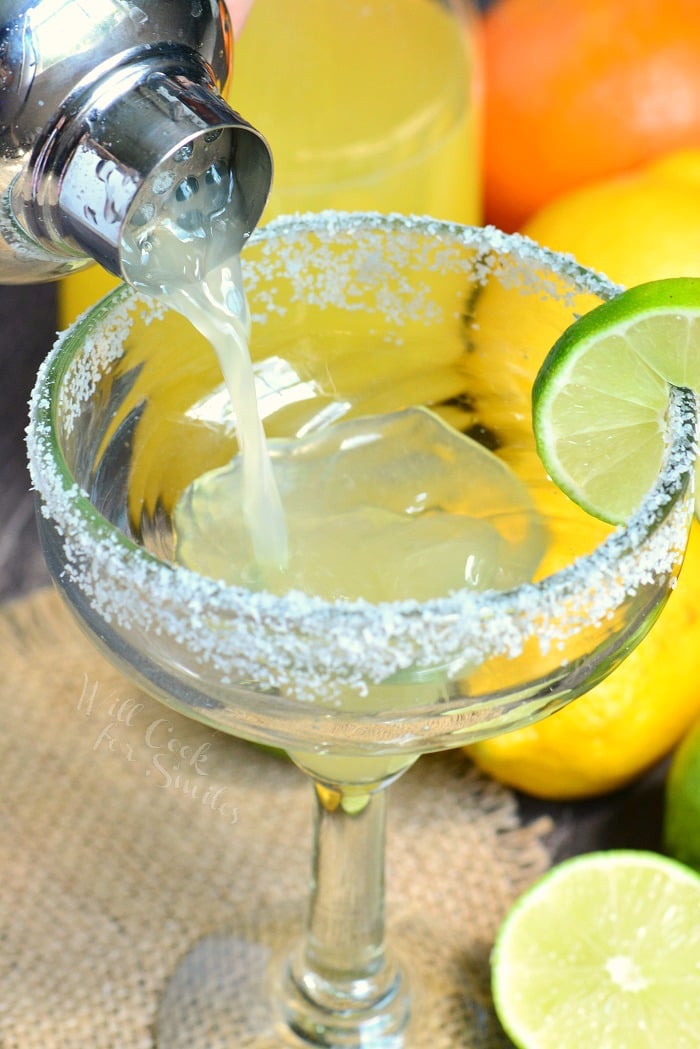 pouring margarita into a glass