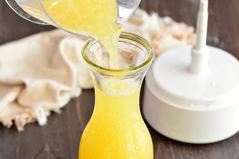 pouring citrus juice into a jar