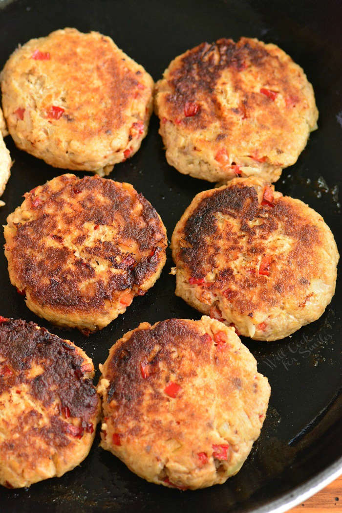 cooked salmon patties in the pan vertical view