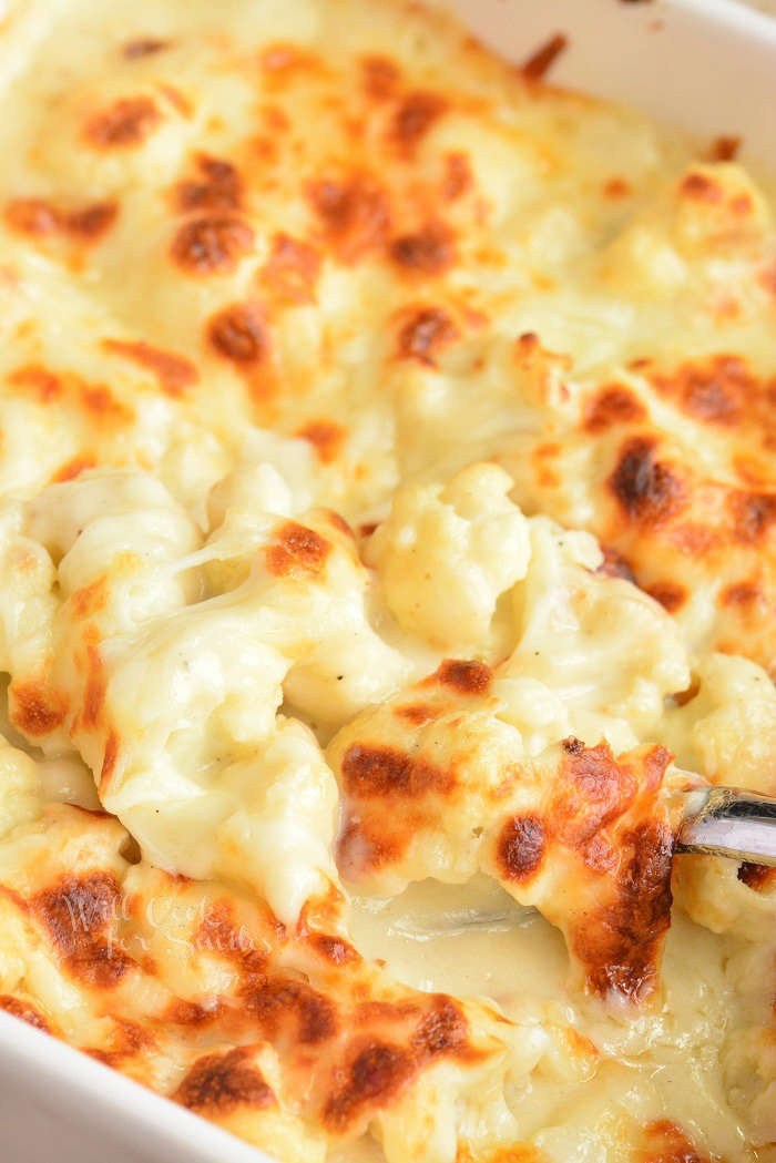 scooping out cheesy baked cauliflower 