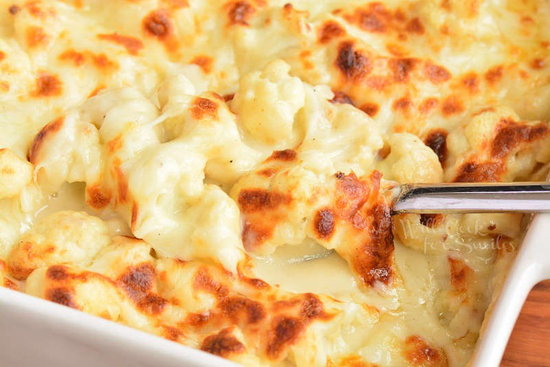 scooping cooked baked cheesy cauliflower 