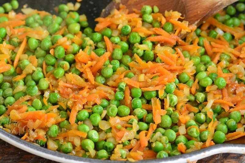 cooked onions, carrots, and peas in the pan