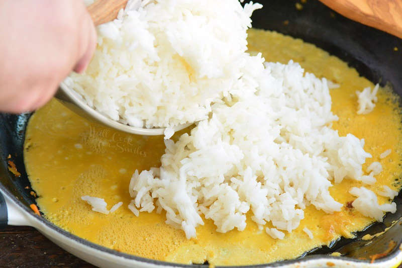 adding rice into the pan with egg