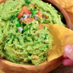 closeup of scooping guac with a chip.