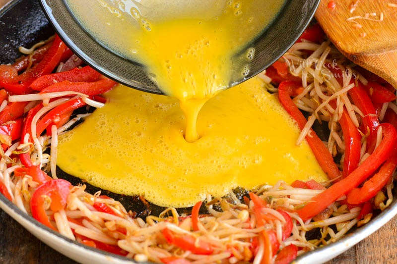 pouring whisked egg into the center of the pan