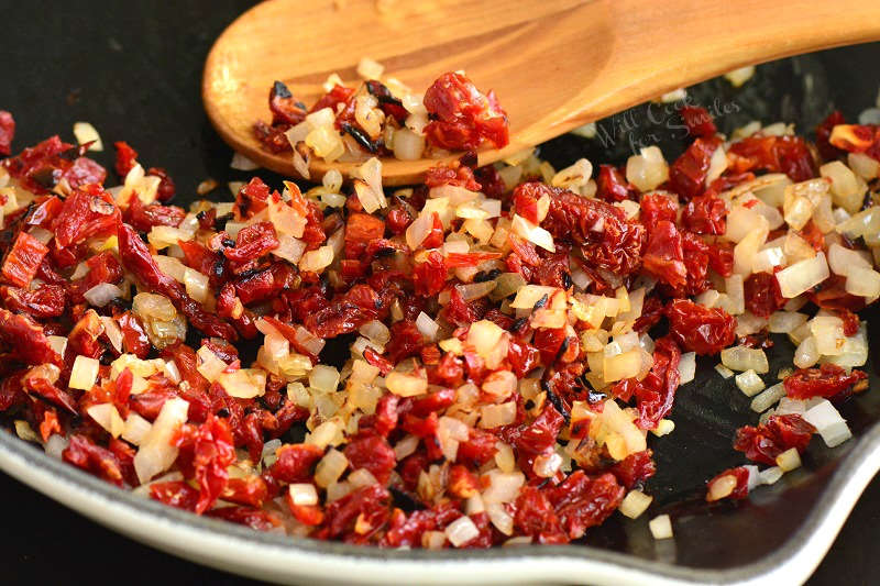 sauteed sun-dried tomatoes and onions in a pan