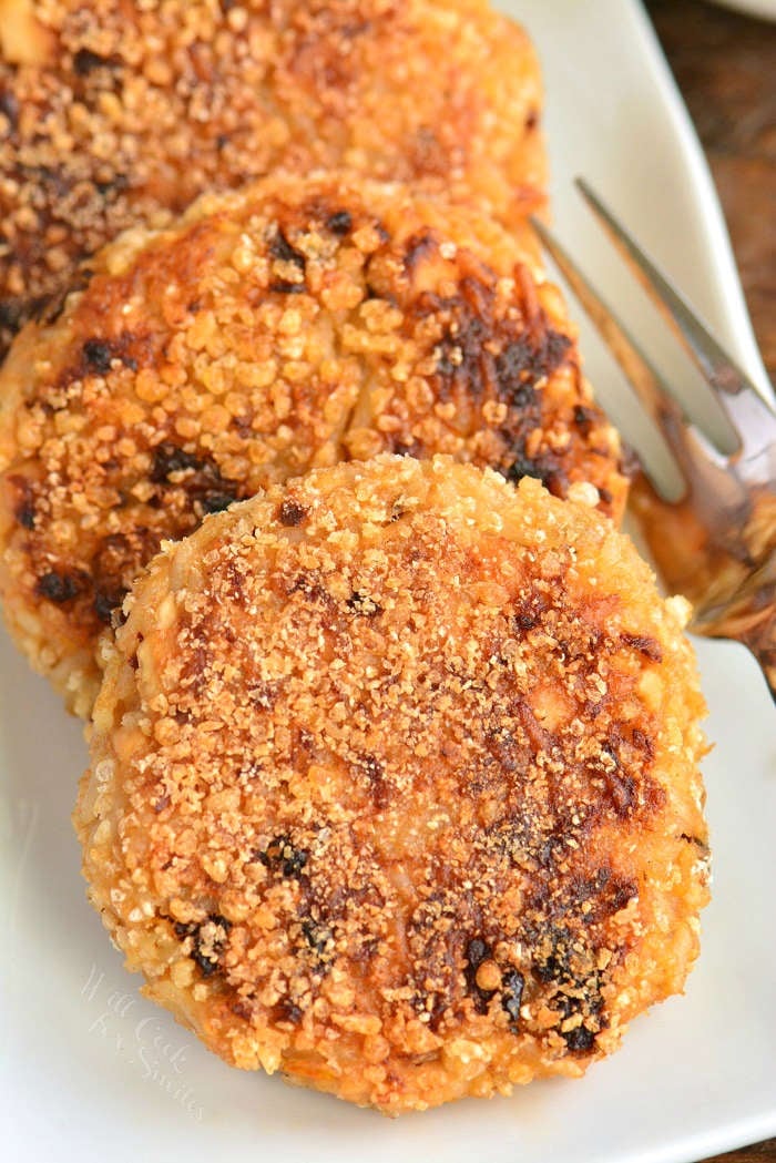 cooked salmon and rice patties on the plate with a fork