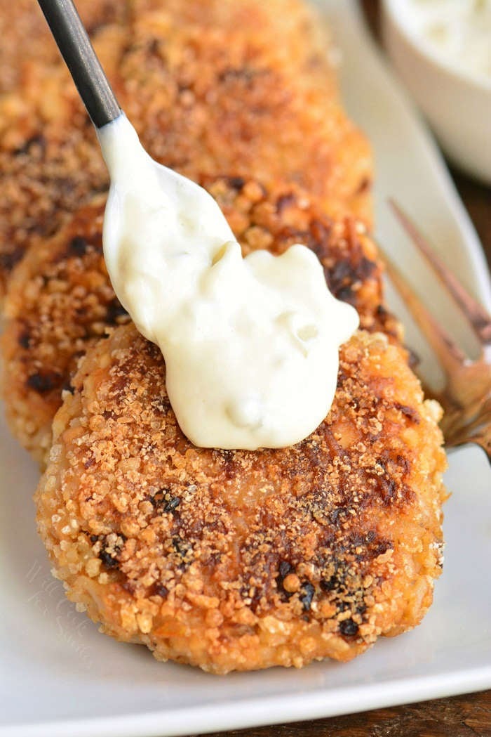 putting the sauce on top of cooked patty with a spoon