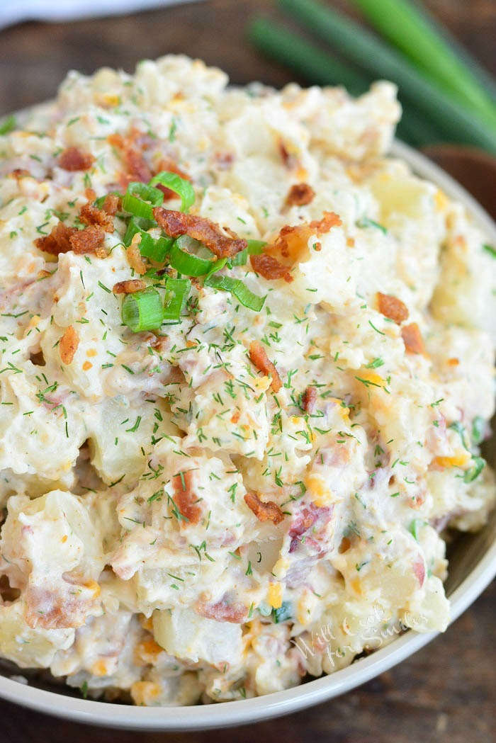 closeup of potato salad with green onions and bacon on top