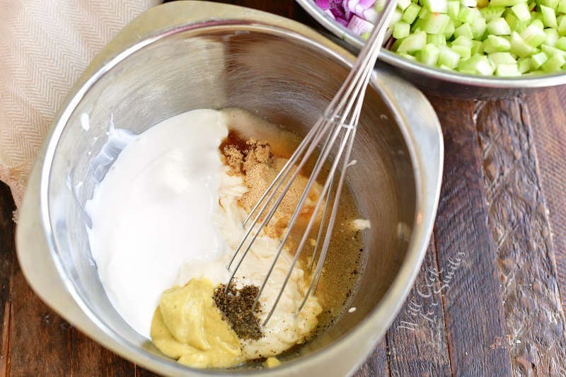 ingredients for the dressing in a mixing bowl with a whisk