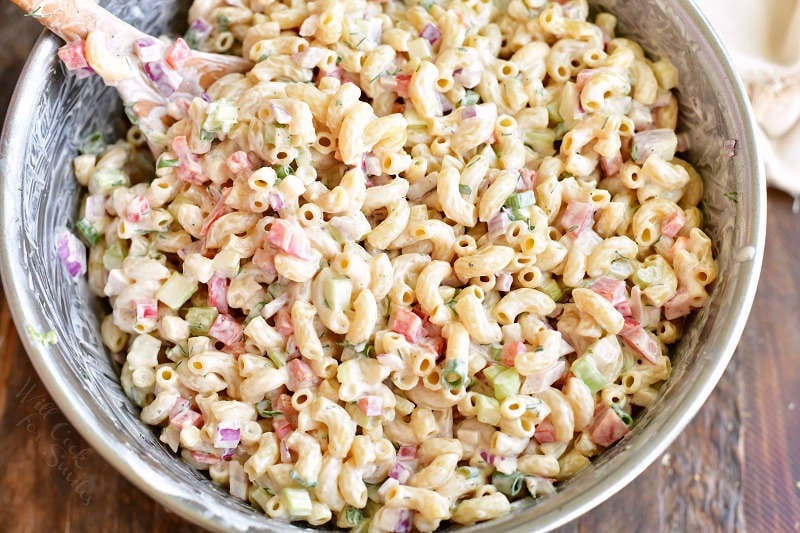 mixing macaroni salad in a metal mixing bowl