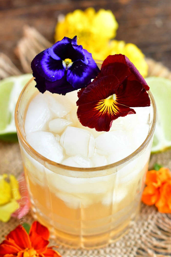 top view of cocktail in the glass with crushed ice and two flowers on top