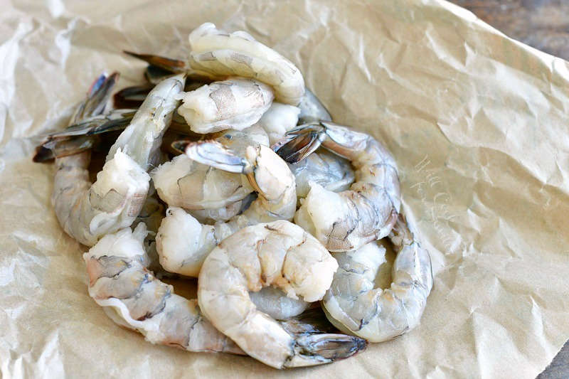 several shrimp together cleaned but with tails on waxed paper