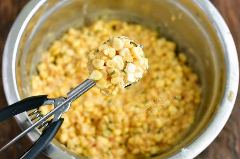 cookie scoop filled with corn mixture and bowl of corn mixture on the beackground