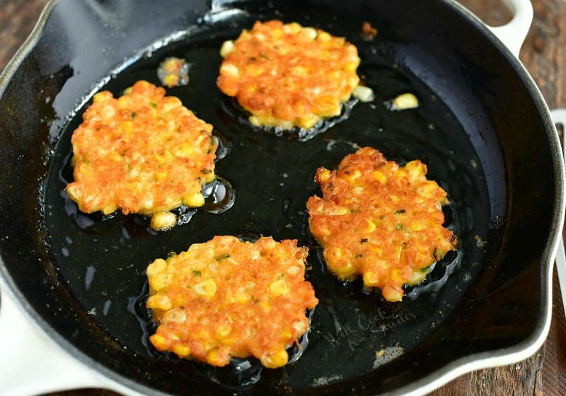 four fried fritters in the cast iron pan in cooking some oil