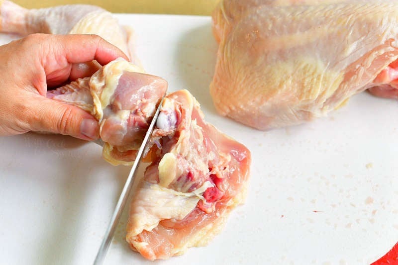 cutting in between the joint to separate drumstick from the thigh
