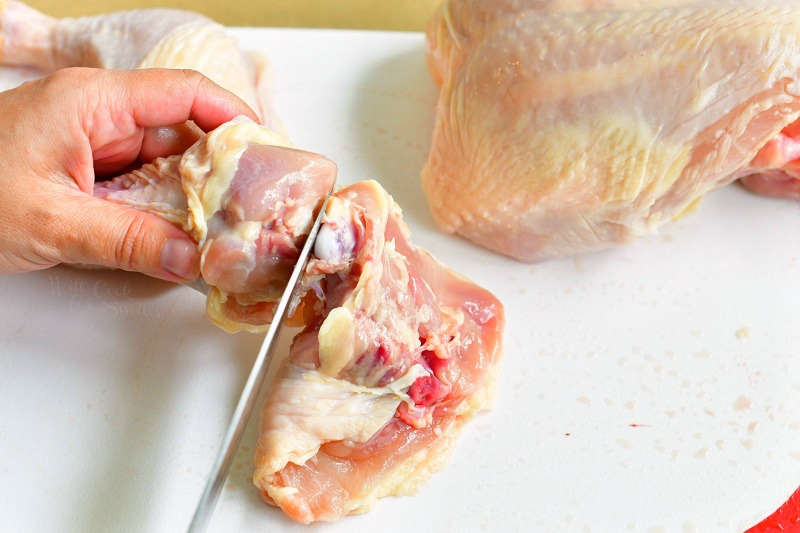 cutting in between the joint to separate drumstick from the thigh