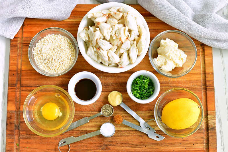 ingredients for crab cakes on the cutting board: lump crab, mayo, bread crumbs, lemon, egg, Worcestershire sauce, parsley, Dijon, salt, pepper, cayenne