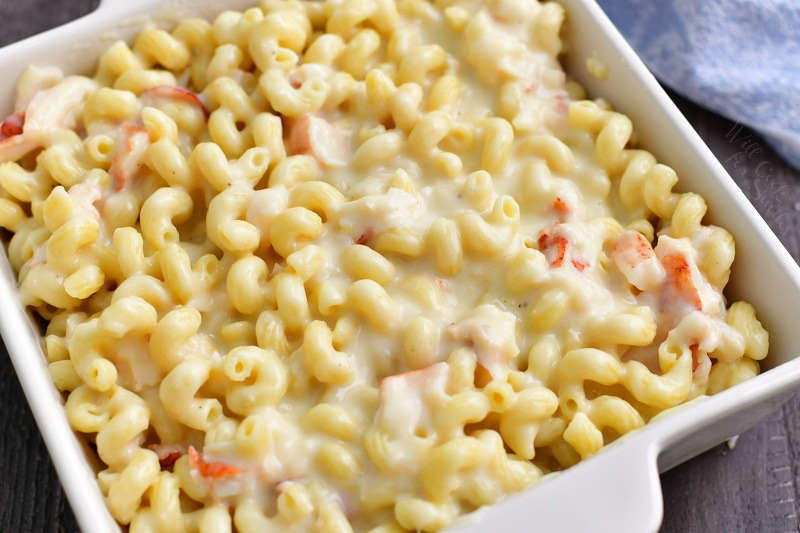 mixed pasta with cheese sauce and lobster meat spread evenly in a while baking dish