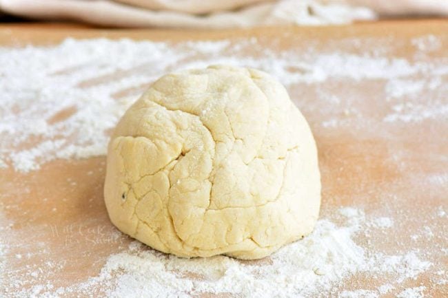 cauliflower gnocchi dough rolled into a ball with flour sprinkled on the work surface