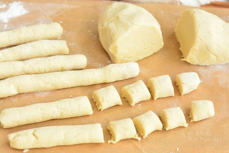 cutting rolled rope-like logs on cauliflower gnocchi dough