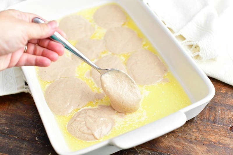 dropping spoonfuls of batter into the baking pan with melted butter