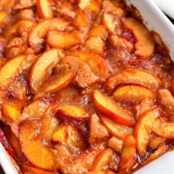 closer view of cooked peach cobbler in a white baking dish