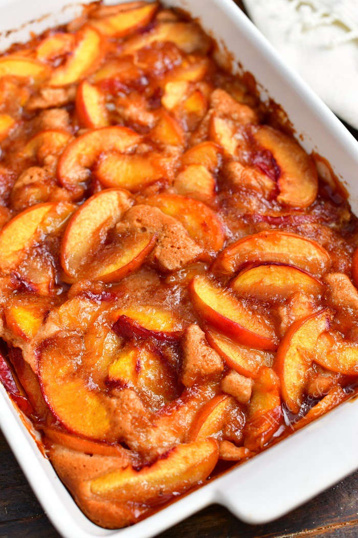 closer view of cooked peach cobbler in a white baking dish