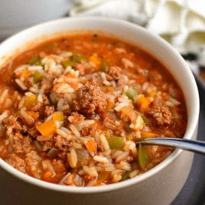 white bowl filled with beef and rice soup - spoon in the bowl