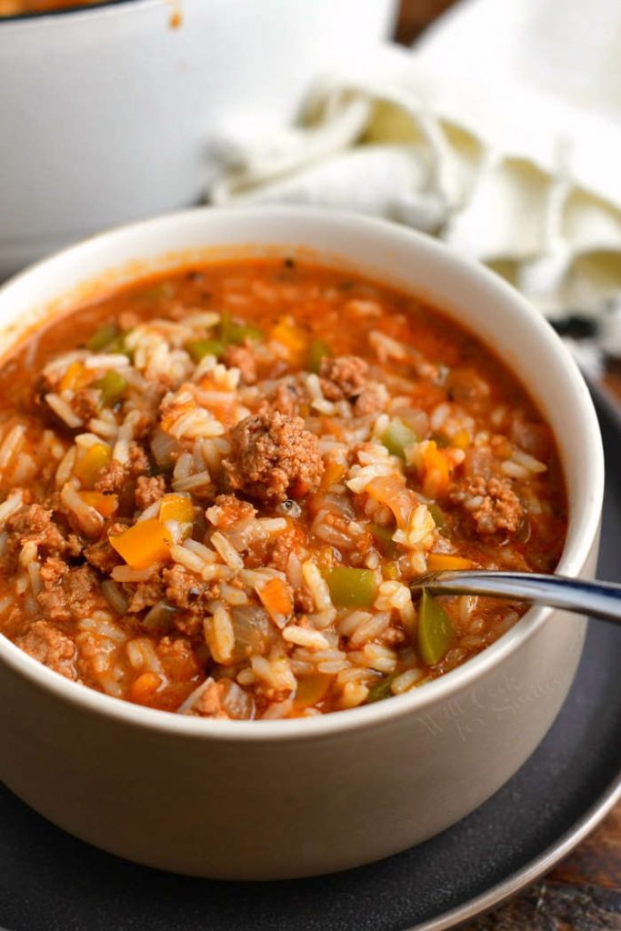 white bowl filled with beef and rice soup - spoon in the bowl
