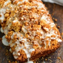 close view of the top of zucchini bread looking at the crumble topping and white icing drizzled over the top