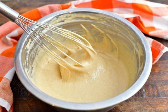 mixing bowl filled with batter and a whisk coming out of the batter