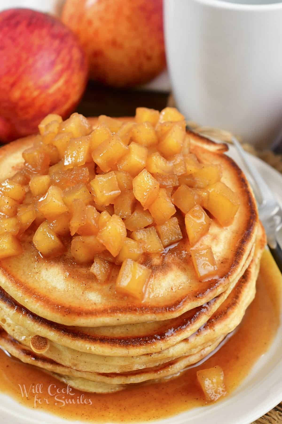 apple pie pancakes topped with cooked apples.