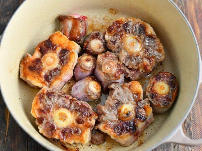 photo shows how to make beef stock by searing beef bones in large pot