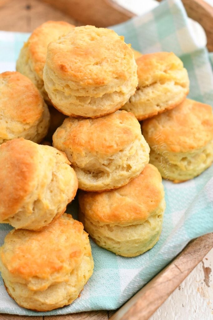 overhead photo: freshly baked buttermilk biscuits on mint green and white cloth kitchen towel