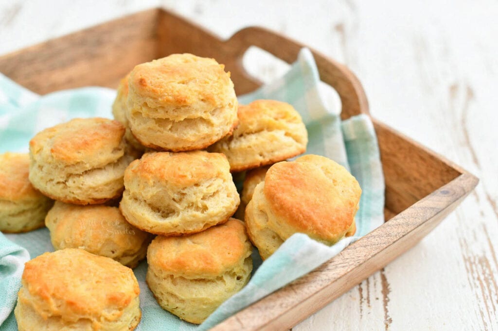 homemade country biscuits on green cloth napkin in wood serving tray