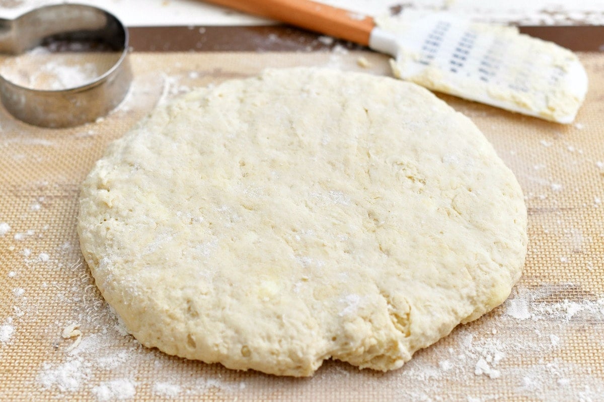 unbaked circle of dough on floured pastry mat