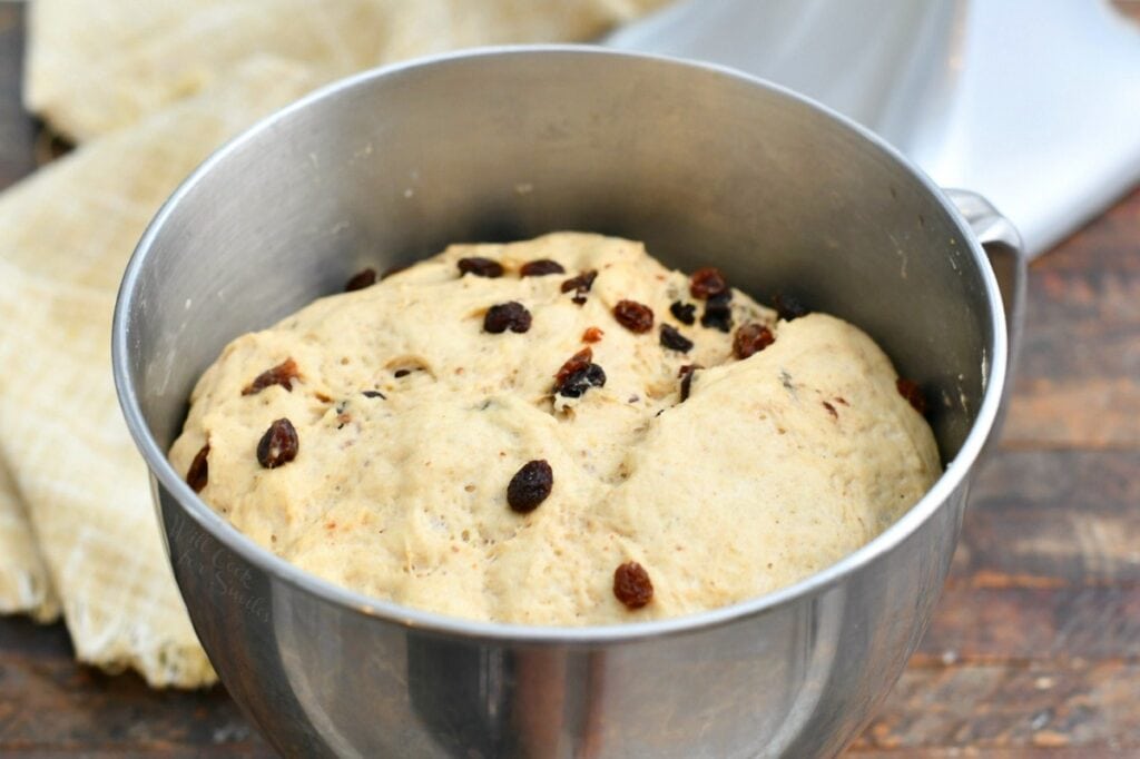 unbaked yeast dough rising in stainless steel mixing bowl