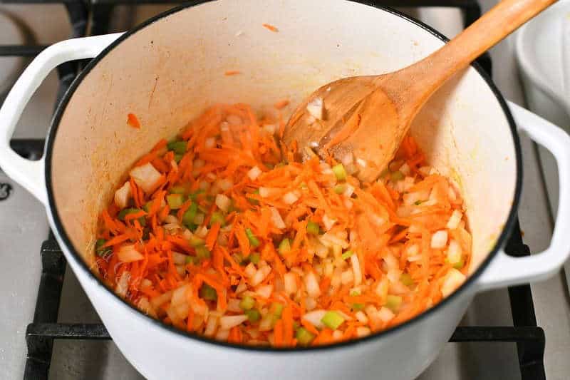 sauteeing shredded carrots, celery, and onion in large soup pot
