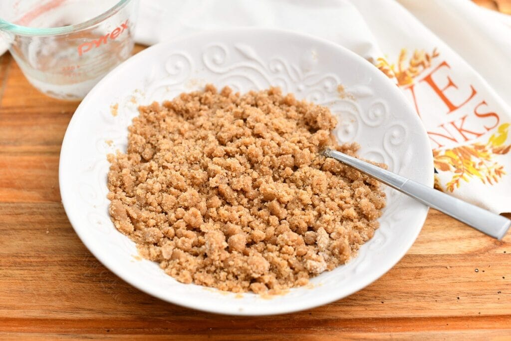 brown sugar crumble topping in white bowl with spoon