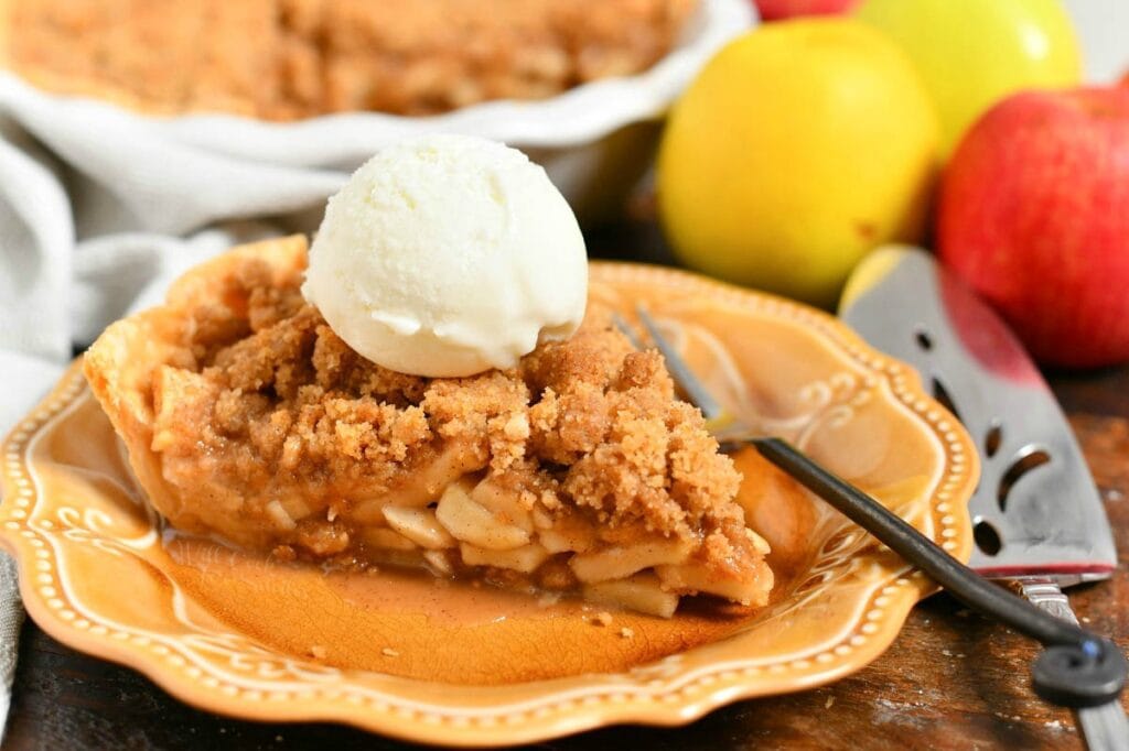 slice of homemade Dutch apple pie topped with scoop of vanilla ice cream