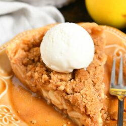 slice of Dutch apple pie with scoop of vanilla ice cream on brown plate