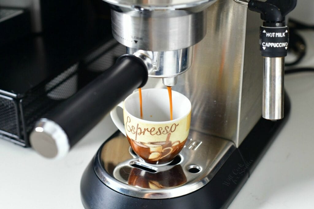 espresso maker pouring espresso into small mug