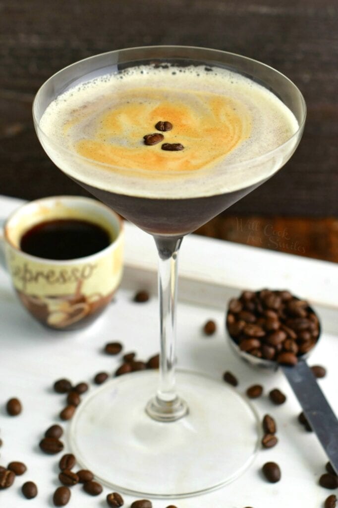 top view of espresso martini in a tall glass with beans and espresso shot around