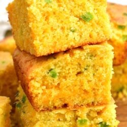 3 stacked squares of cheesy cornbread with green chili peppers