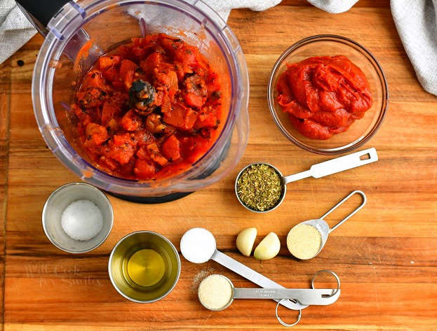 overhead: ingredients in bowls and measuring spoons to make homemade pizza sauce recipe