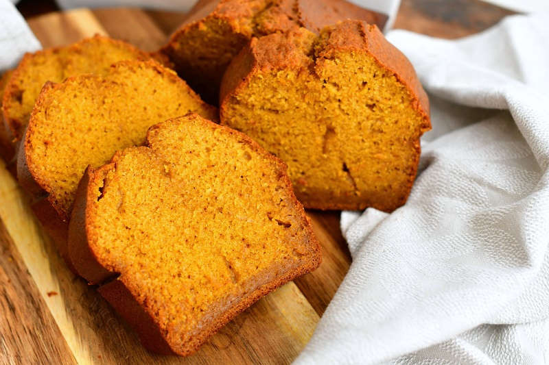 slices of pumpkin quick bread on wood serving board with white linen napkin