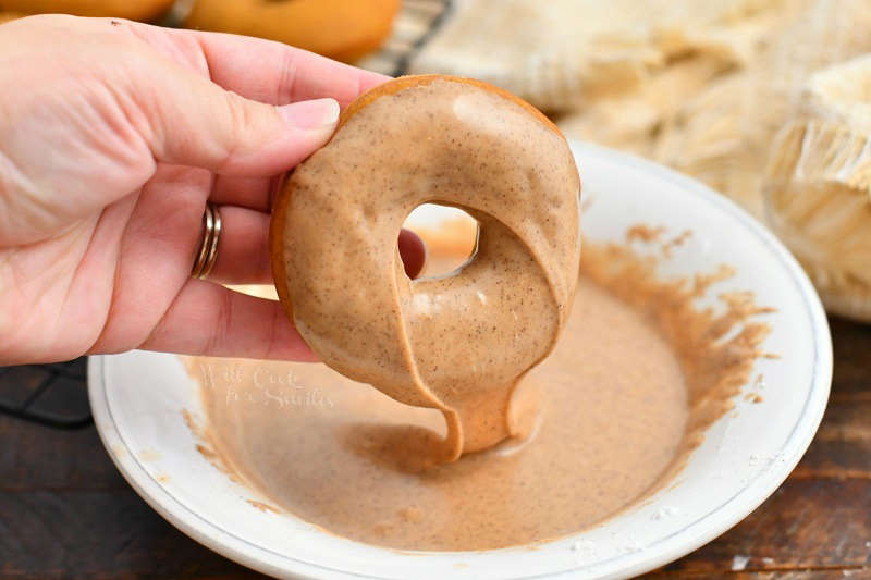 dipping cake donut into bowl of espresso glaze